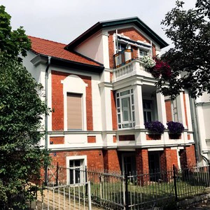 Bachsteinhaus mit Bäumen und Vorgarten